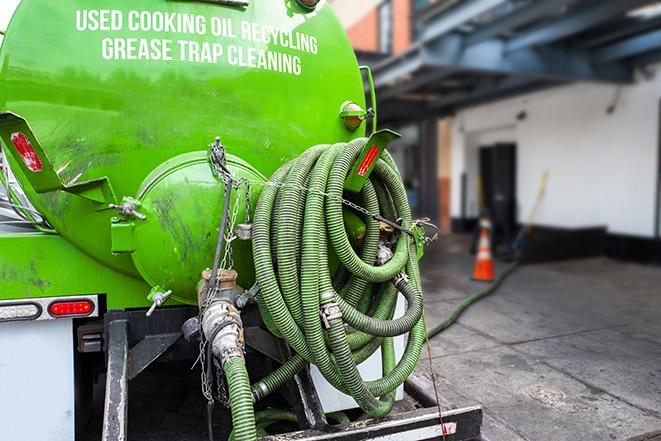 a technician pumping a grease trap in a commercial building in El Paso, IL